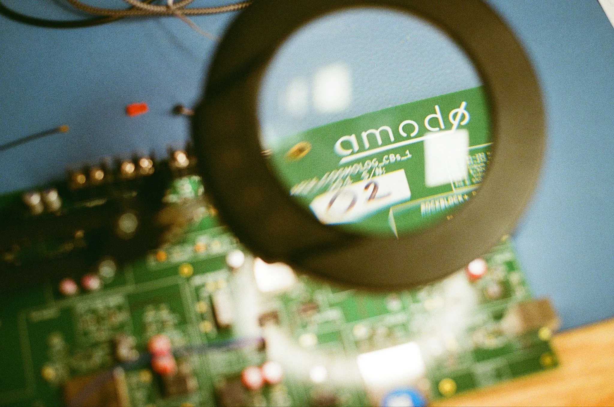 A magnifying lamp over a green circuit board