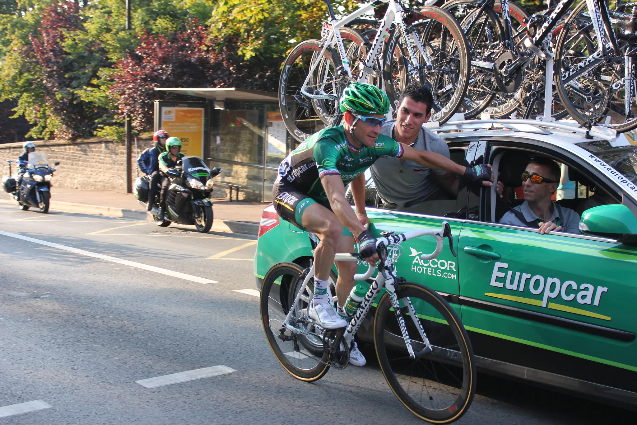 Thomas Voeckler riding beside a Europcar team car at the 2013 Tour de France