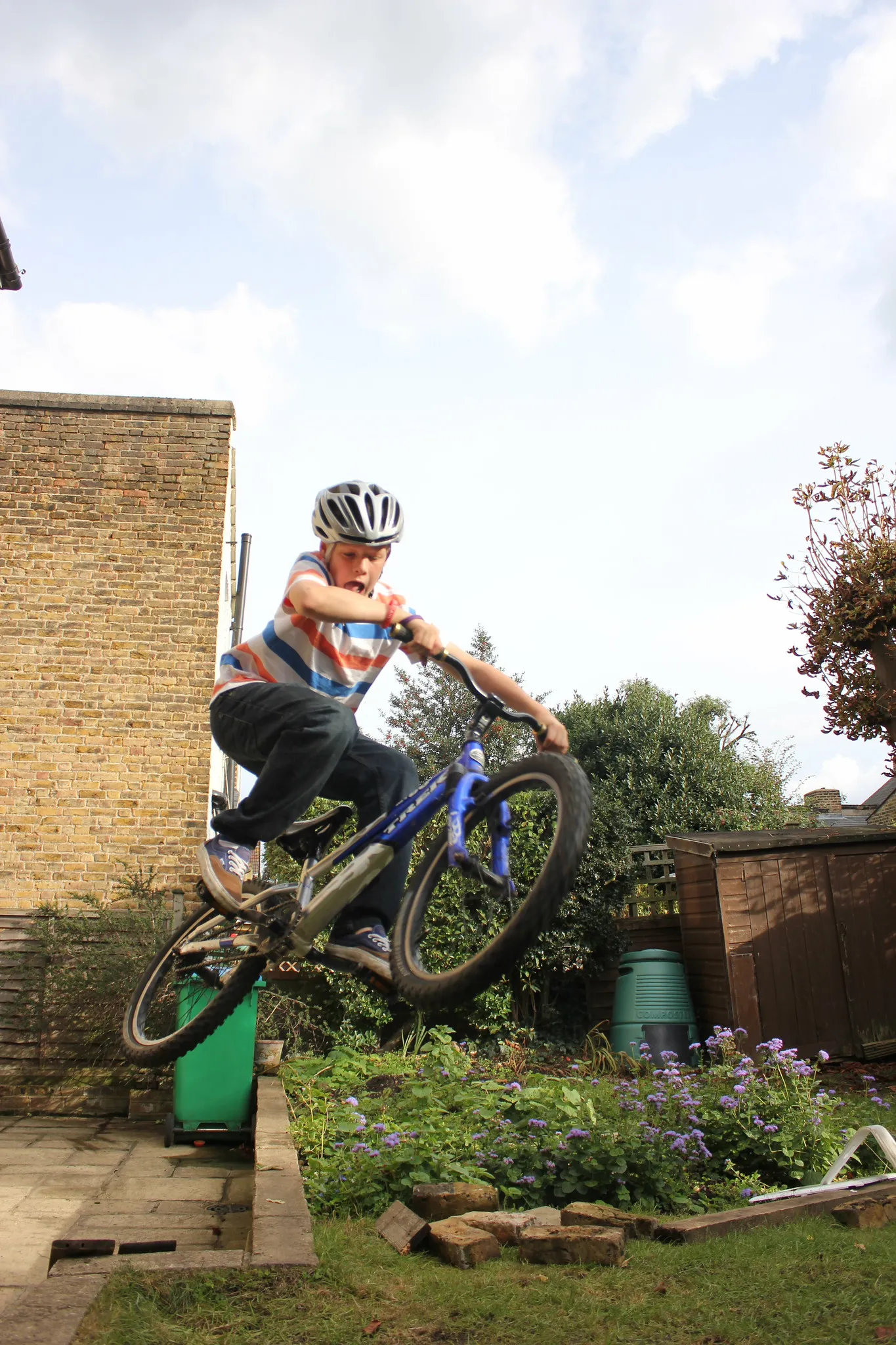 A rider jumping a bike off a garden wall