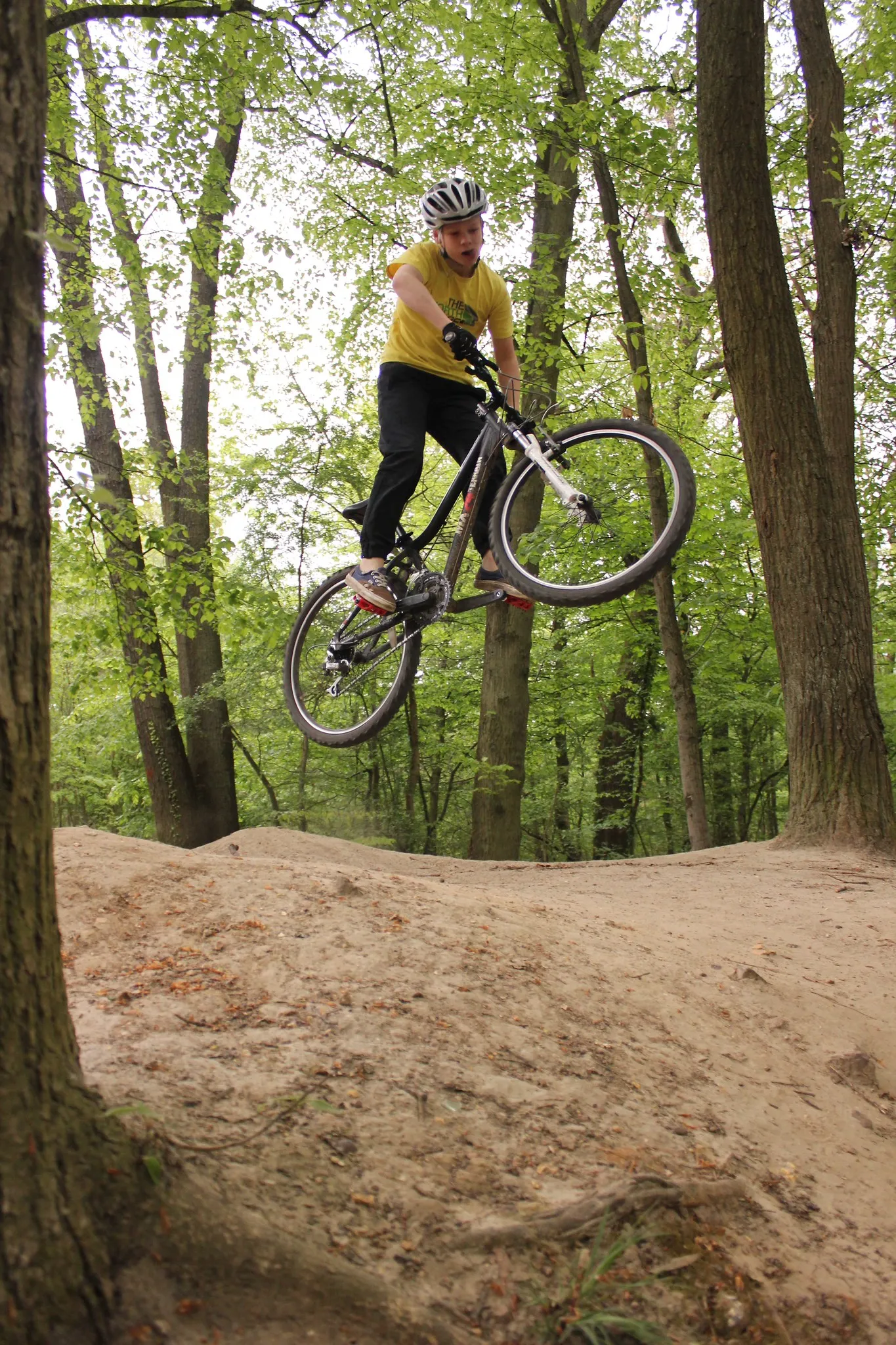 A mountain biker whipping the bike sideways over a dirt jump