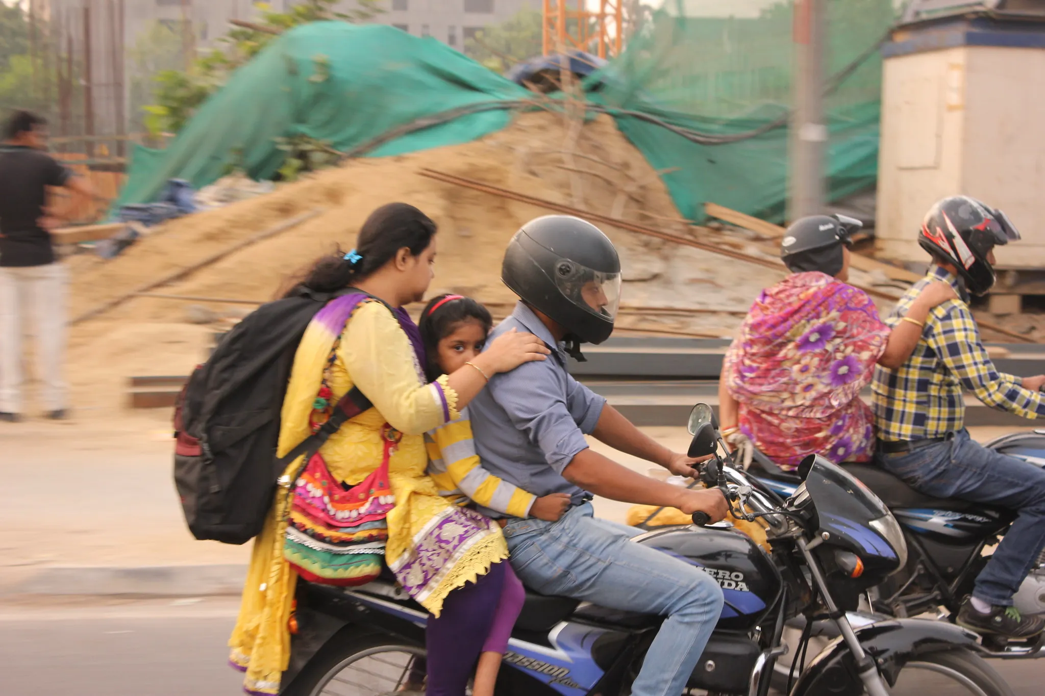 A family riding together on a motorbike in Delhi traffic